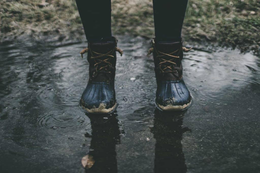 person standing in puddle with fishing shoes