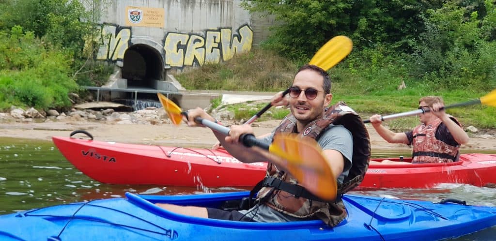 guy kayaking with paddle in ravine
